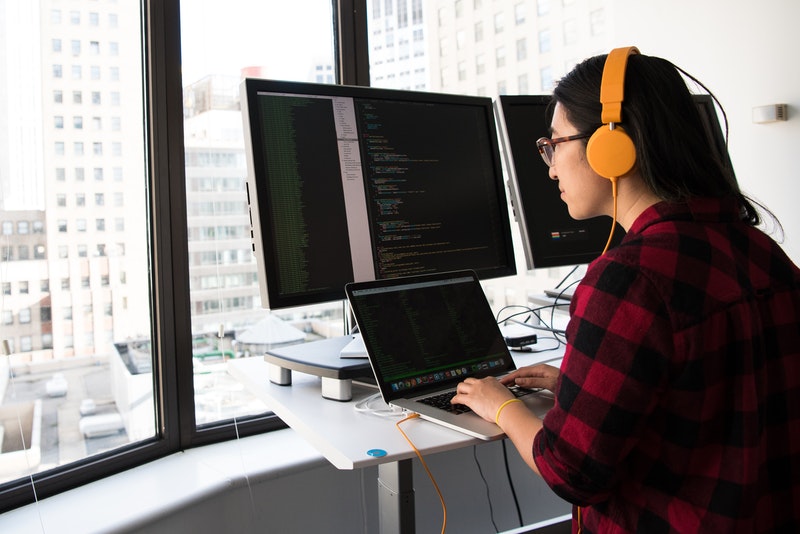 Woman coding on a computer_8 Benefits of Salesforce Apex