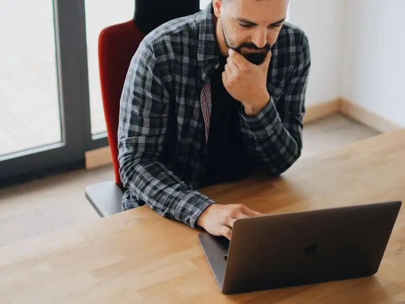 8-Best-Practices-for-DevOps-Security-in-2021-1 Man looking at computer_AutoRABIT