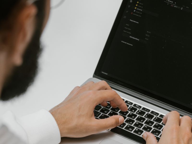 Man coding on a laptop_Why You Should Backup Your Salesforce Metadata