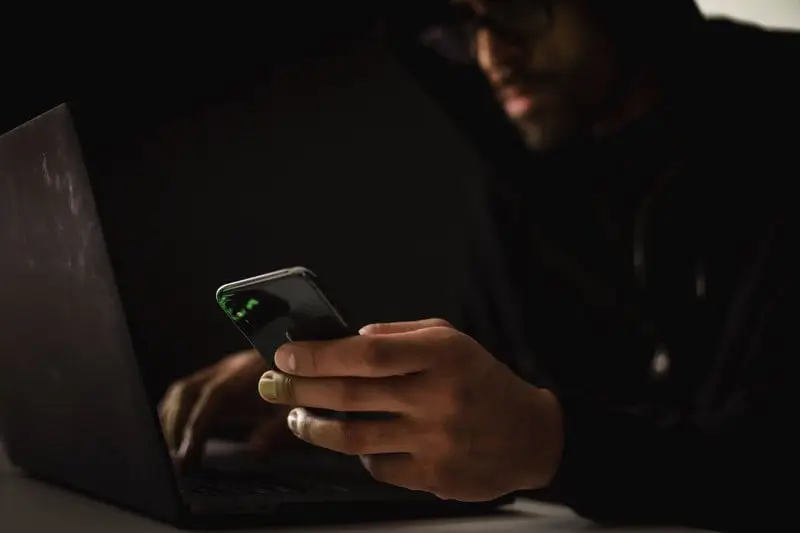 How-Salesforce-Metadata-Affects-Compliance-2 Man Using Phone and Computer_AutoRABIT