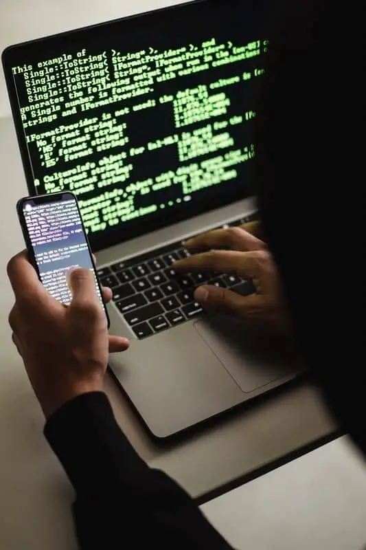 The-Popularity-of-Salesforce-Also-Makes-It-a-Target-Are-You-Prepared-1 Hacker on phone and computer