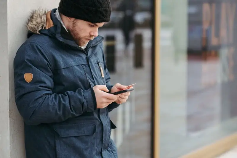 How-Frequent-Updates-Help-Keep-up-With-the-Financial-Industry-2 Man using credit card with phone_AutoRABIT